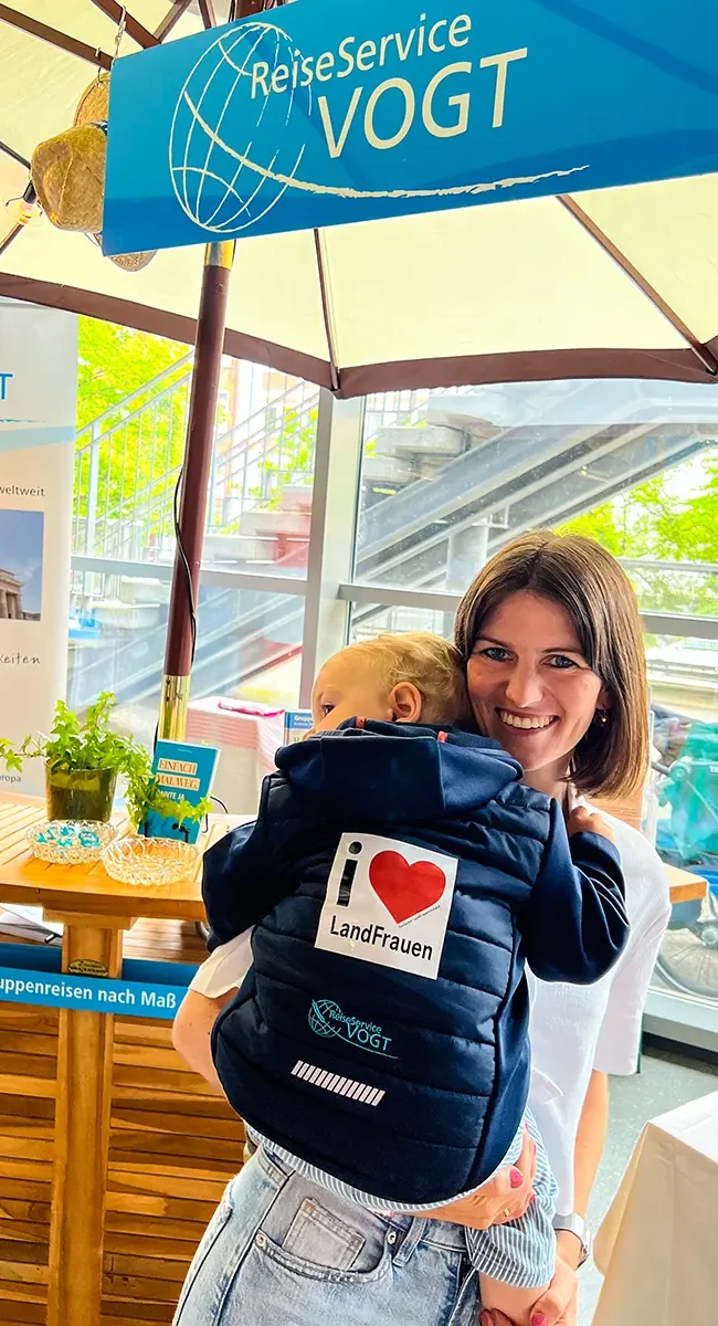 Geschäftsführerin Sarah Vogt mit ihrem Sohn Lenni am Messestand. Auf seiner Jacke ein Aufkleber mit "I love LandFrauen".