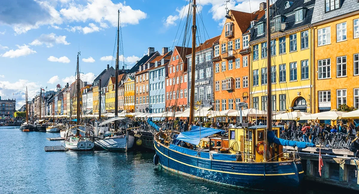 Der malerischen Kanal in Kopenhagen, Dänemark, bekannt für seine farbenfrohen Stadthäuser und historischen Holzschiffe.