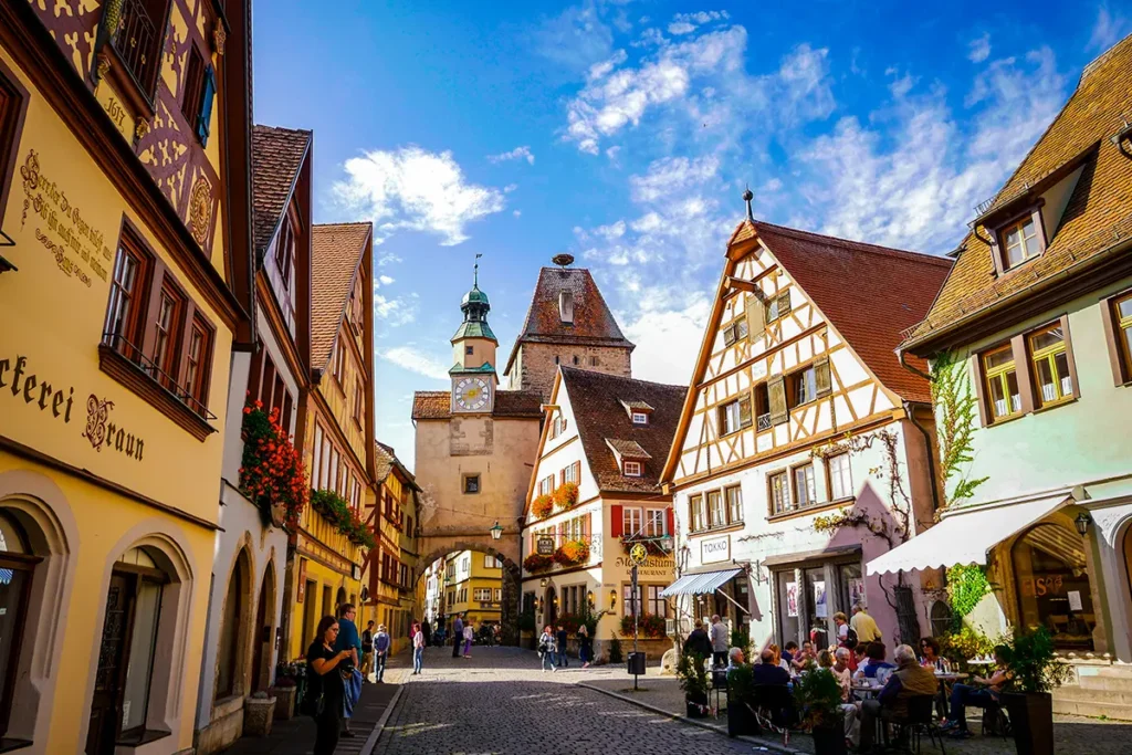 Eine historische Gasse in Rothenburg ob der Tauber mit bunten Fachwerkhäusern und dem Markusturm.