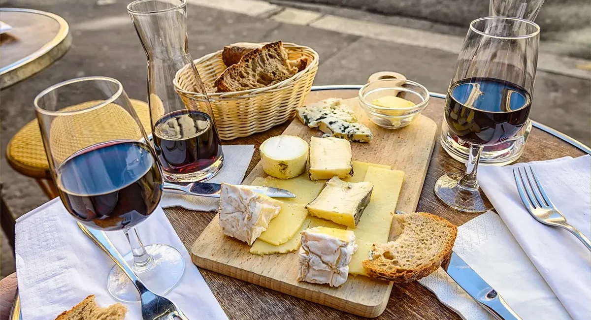 Ein Käsebrett mit französischem Käse und Brot, dazu gibt es Rotwein