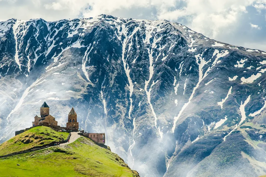 Blick auf die Gergetier Dreifaltigkeitskirche am Fuß des Bergs Kasbek, der im Kaukasus Hochgebirge in Georgien liegt.