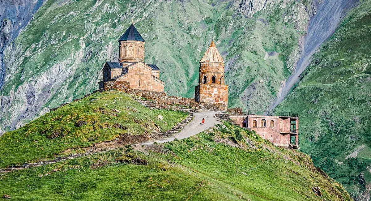 Blick auf die Gergetier Dreifaltigkeitskirche am Fuß des Bergs Kasbek, der im Kaukasus Hochgebirge in Georgien liegt.
