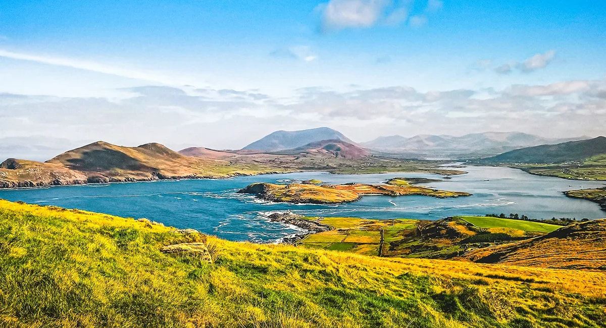 Blick auf einen Teil des Ring of Kerry, eine 179,0 km lange Panoramaküstenstraße in Irland, die an Klippen, Seen und grünen Feldern und Hügeln vorbeiführt.