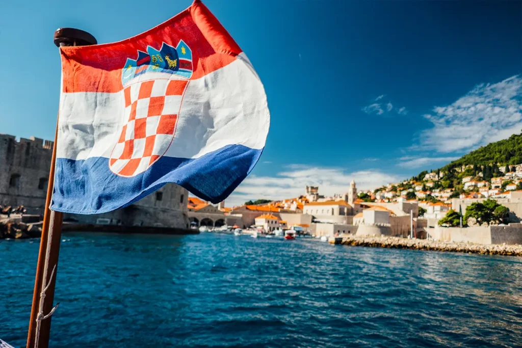 Eine kroatische Flagge weht vor dem Hafen einer Stadt.
