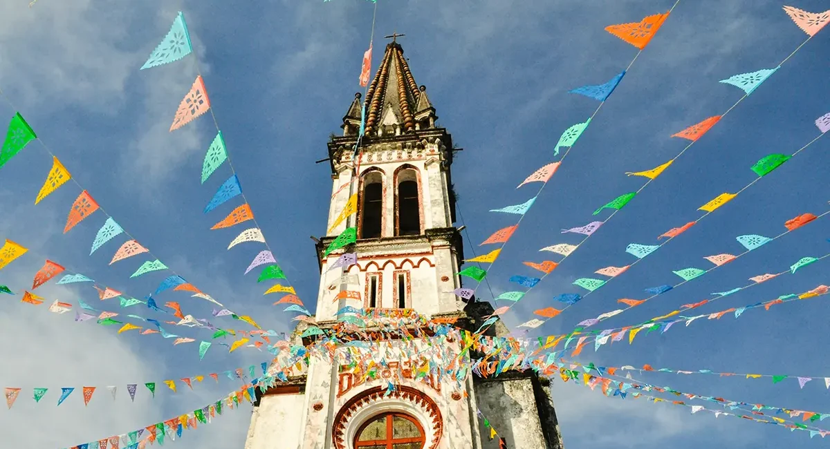 Eine Pfarrkirche in Mexiko, die mit bunten Papiergirlanden geschmückt ist.