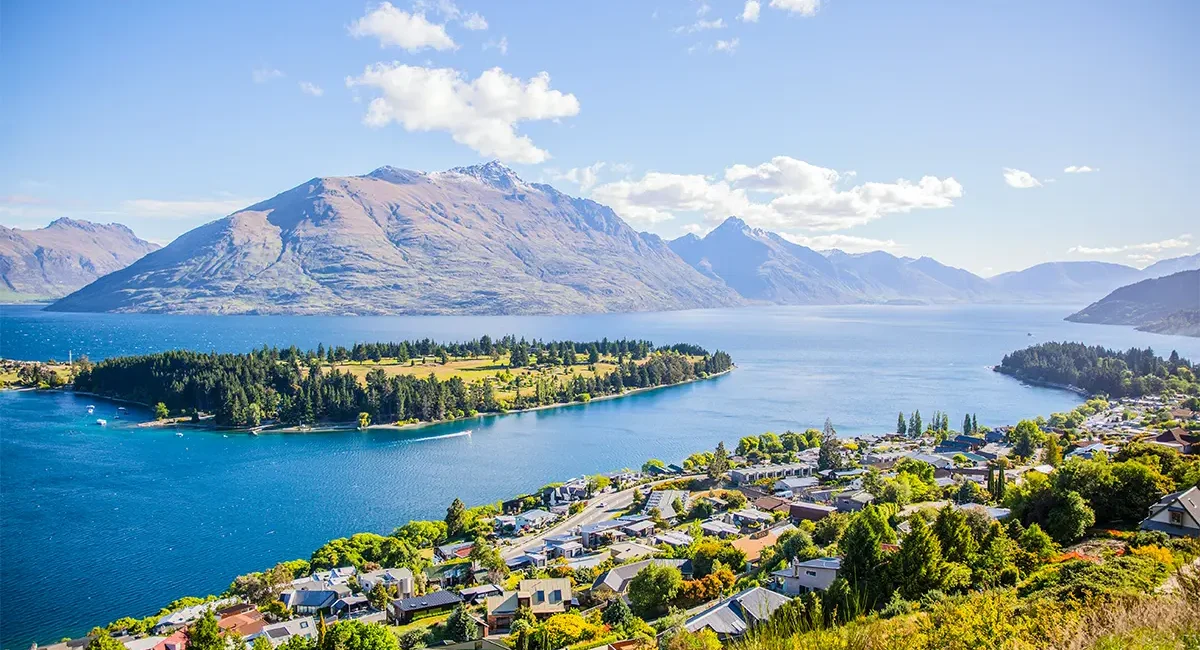 Der Panoramablick auf die Stadt Queenstown am Ufer eines großen Sees, umgeben von den majestätischen Bergen in Neuseeland.