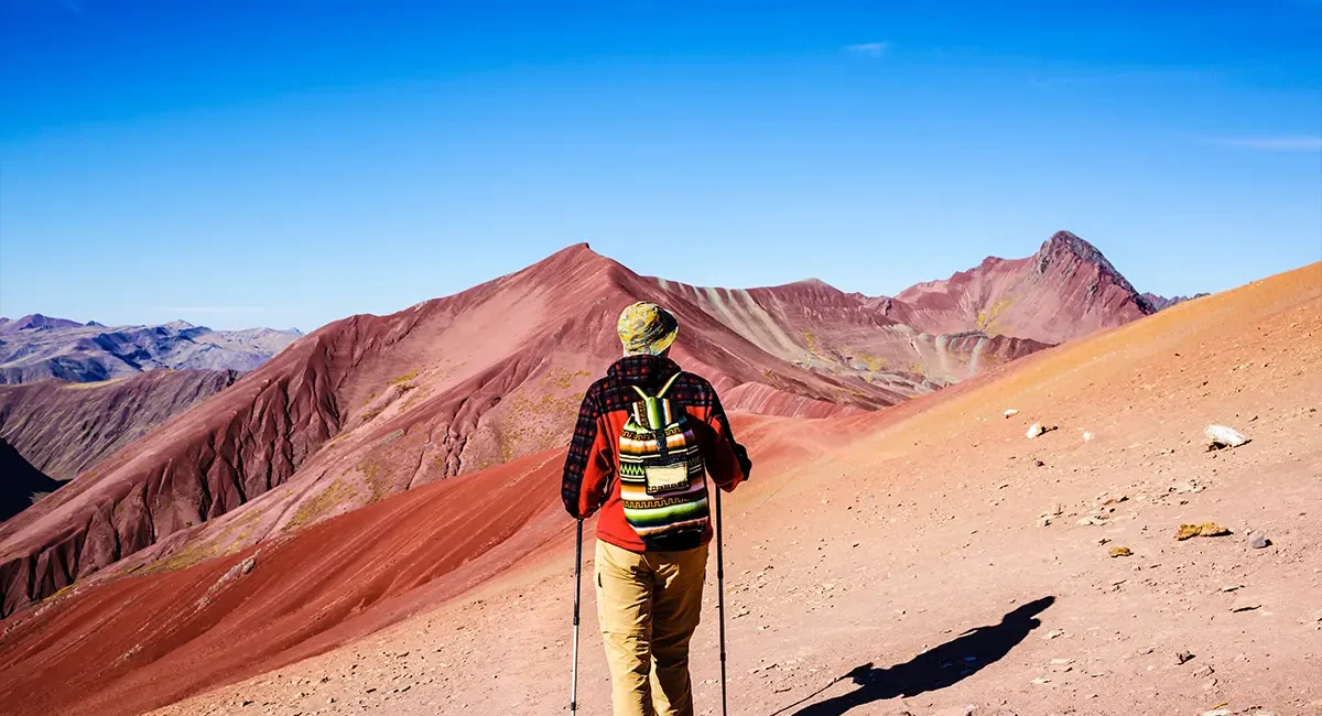 Ein Wanderer in der roten Landschaft des Regenbogenberges in Peru.