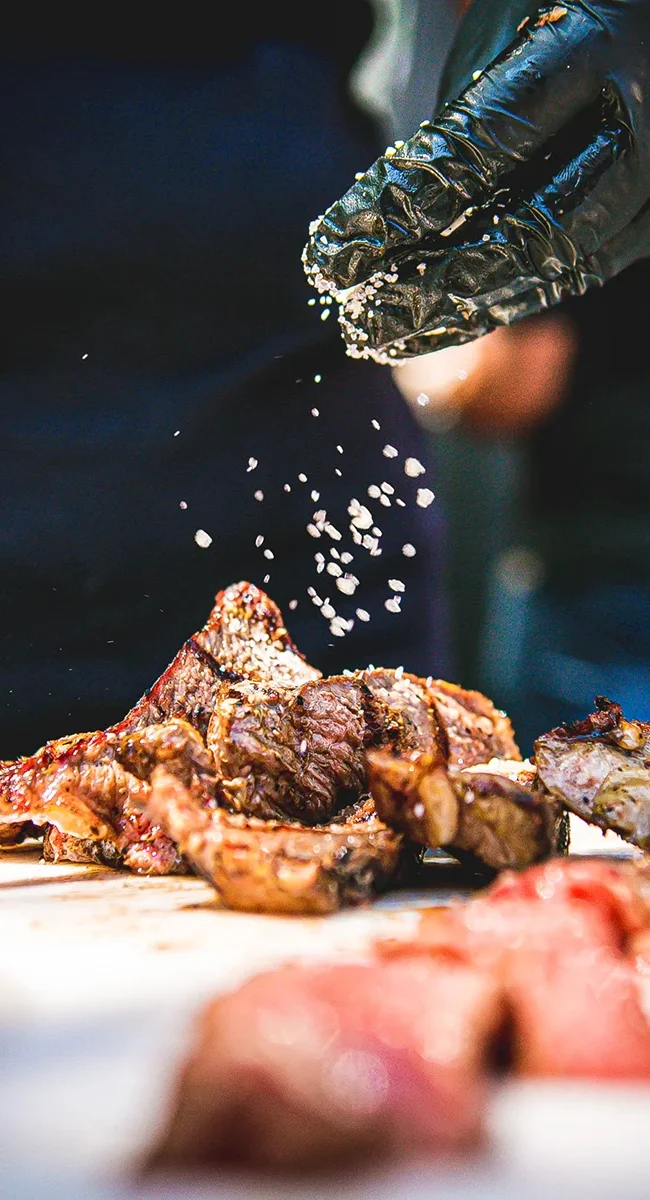 Ein Koch würzt saftiges Fleisch für ein traditionelles brasilianisches Barbecue.