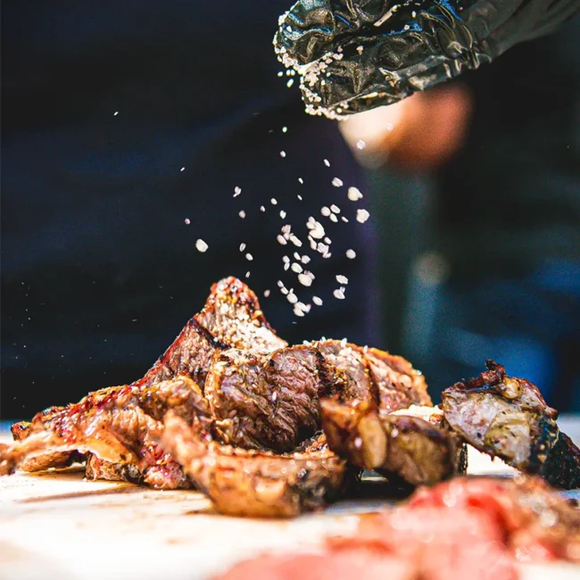 Ein Koch würzt saftiges Fleisch für ein traditionelles brasilianisches Barbecue.