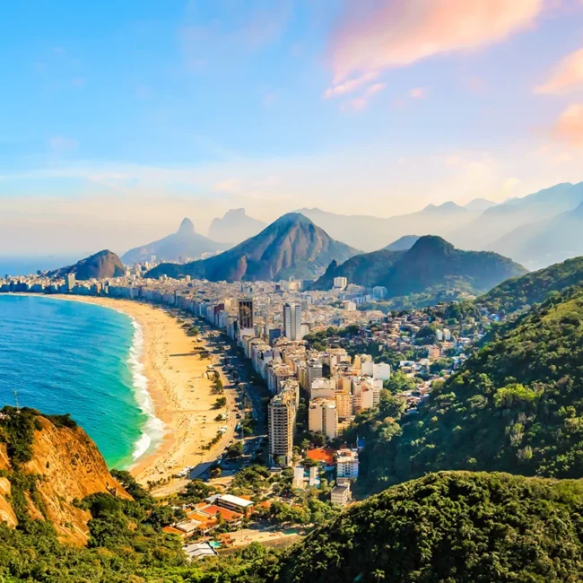 Die brasilianische Stadt Rio de Janeiro mit seinem berühmten Strand, dem Meer und dem markanten Bergland im Hintergrund.