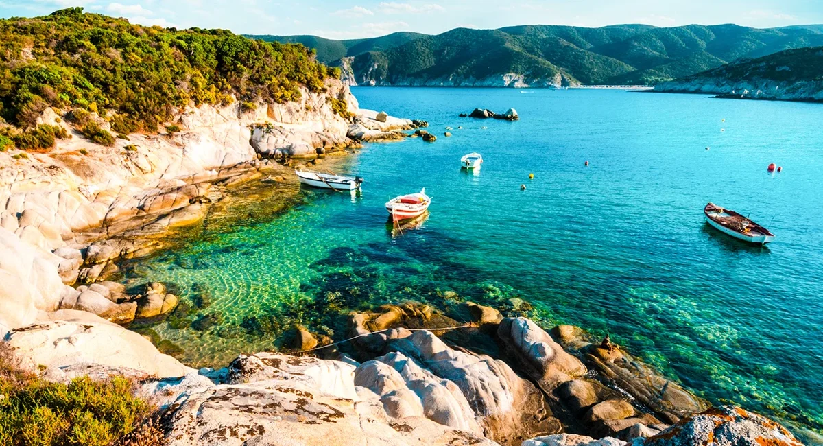 Die Küstenlandschaft mit kleinen Fischerbooten auf Chalkidiki in Griechenland.