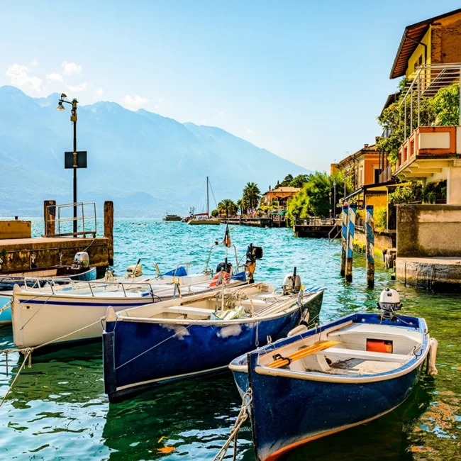 Kleine Fischerboote liegen am Hafen des Ortes Limone sul Garda am Gardasee in Italien.