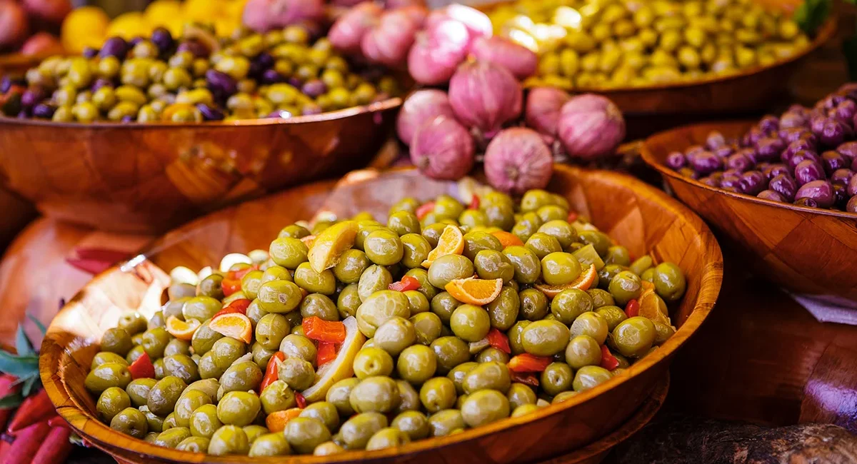 Große Schüsseln mit frischen Oliven an einem Marktstand am Gardasee in Italien.