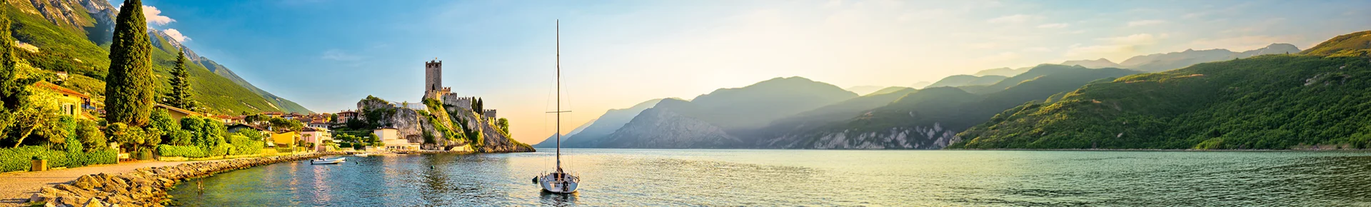 Die Ortschaft Malcesine am Ufer des Gardasees in Italien mit der historischen Skaligerburg, die auf einem Felsen thront.