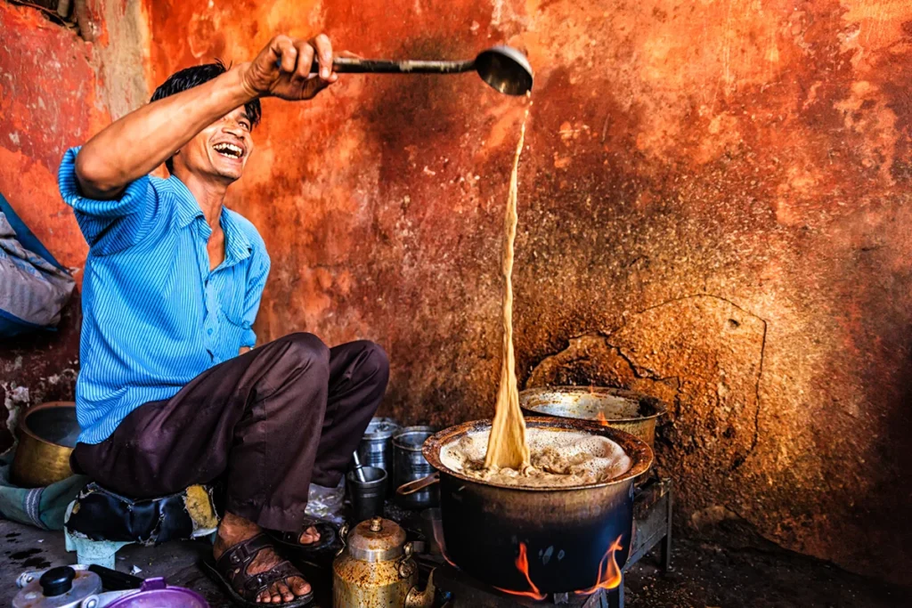 Ein indischer Tee-Verkäufer, der traditionellen Masala Chai in Jaipur, Indien, zubereitet.
