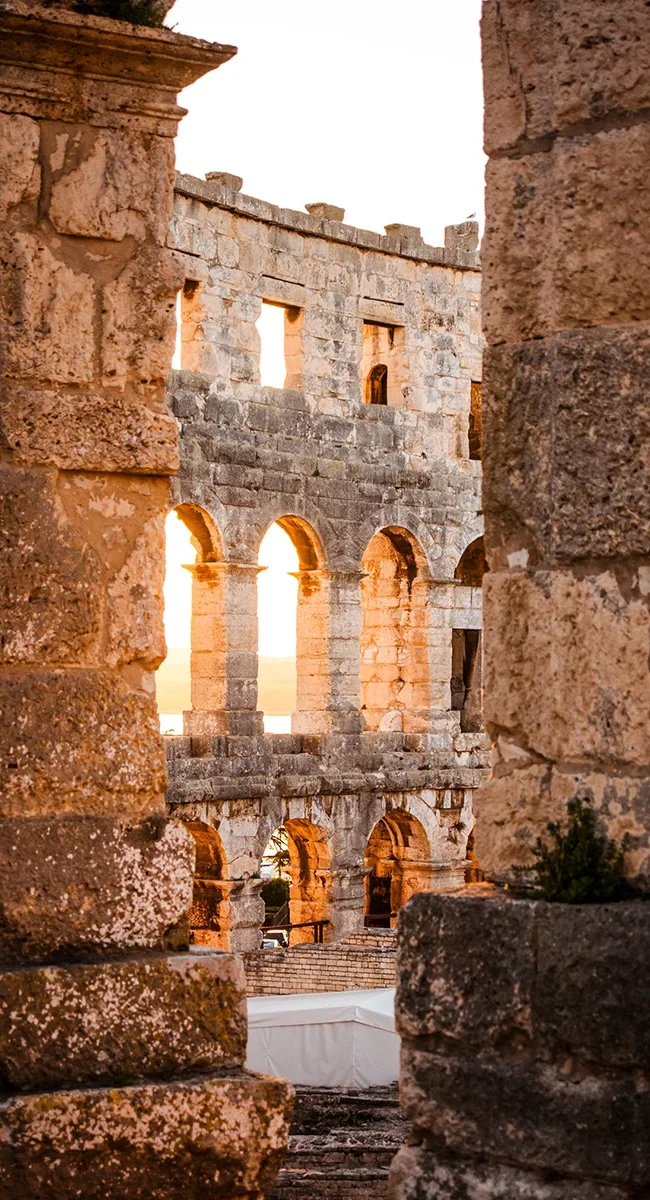 Die antiken Steinruinen und die sonnenbeschienene Fassade des Amphitheaters von Pula in Kroatien.