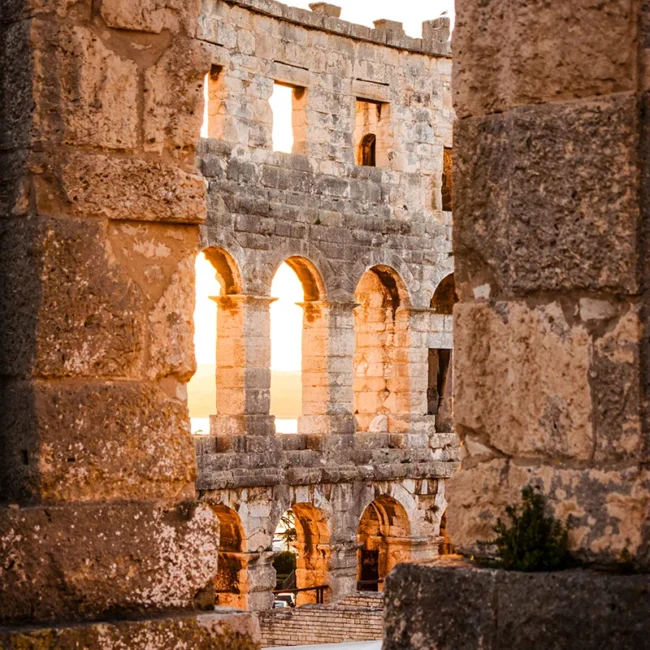 Die antiken Steinruinen und die sonnenbeschienene Fassade des Amphitheaters von Pula in Kroatien.
