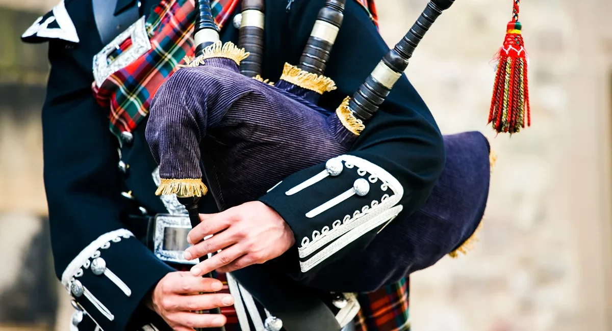 Ein Dudelsackspieler in traditioneller schottischer Kleidung und schottischen Dudelsack.