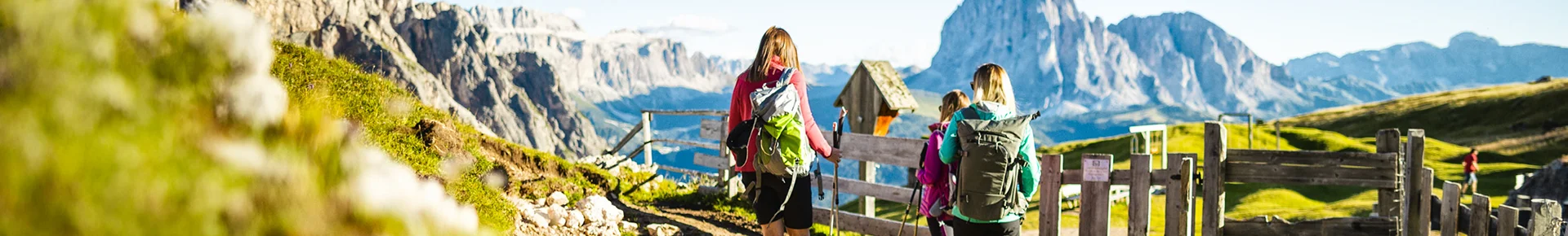 Drei Frauen wandern durch die Berglandschaft der Dolomiten in Südtirol.