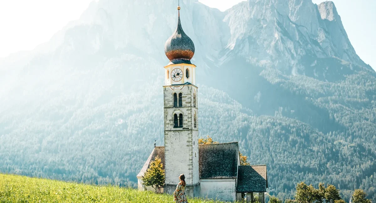 Die Kirche St. Valentin in Seis am Schlern, Südtirol, vor dem mächtigen Schlernmassiv in den Dolomiten.