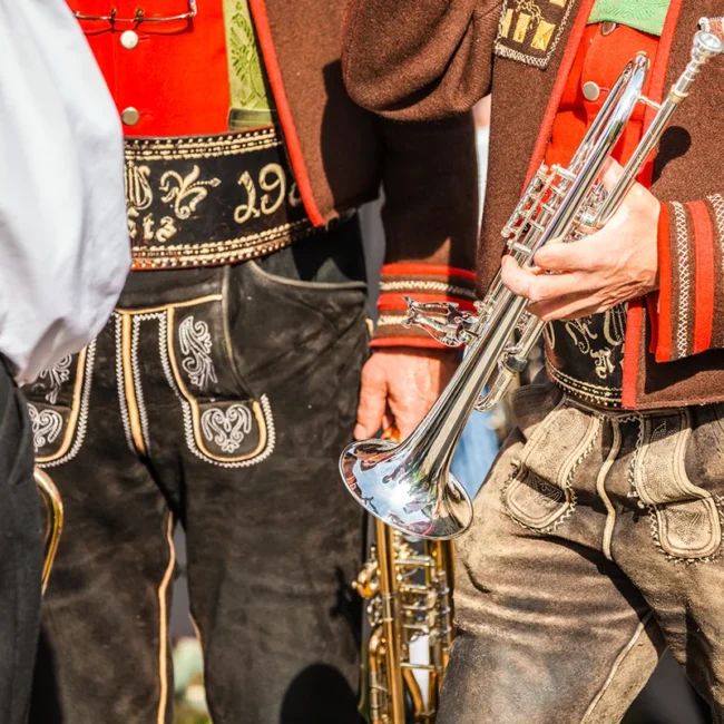 Musikanten in Südtirol mit Lederhosen, Trachtenjacken und Trompeten.