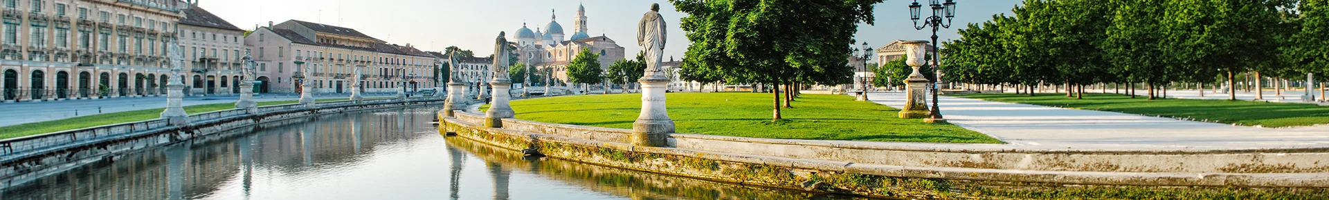 Der Prato della Valle in Padua, einen der größten Stadtplätze Europas, der durch seine zentrale grüne Insel, den umgebenden Wasserkanal und die zahlreichen historischen Statuen geprägt ist.