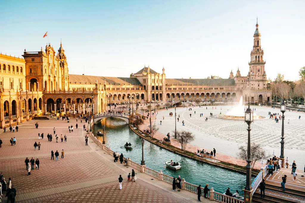 Die Plaza de España in Sevilla mit dem halbkreisförmigen Gebäude und einem Kanal mit Brücken.
