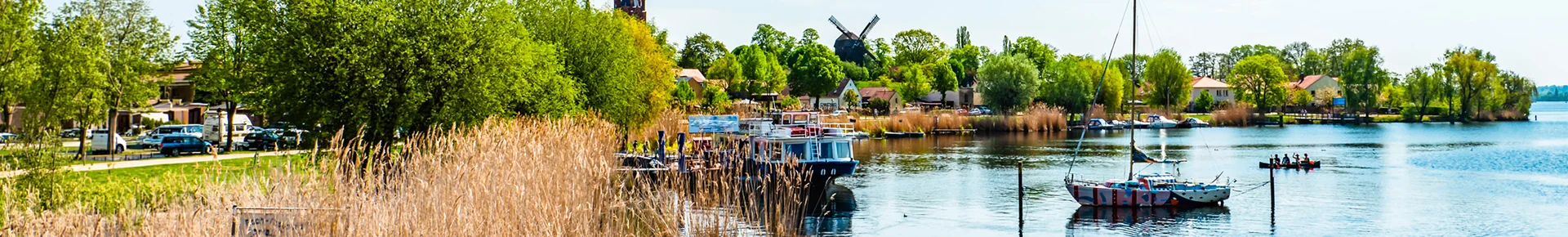 Die idyllische Altstadtinsel von Werder mit ihrer markanten Bockwindmühle, umgeben von Segelbooten und der typischen Flusslandschaft Brandenburgs.