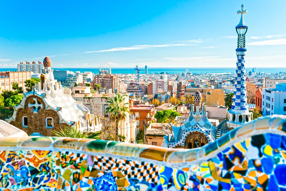 Der Park Güell in Barcelona mit bunten Mosaiken und geschwungenen Formen der Architektur von Antoni Gaudí.