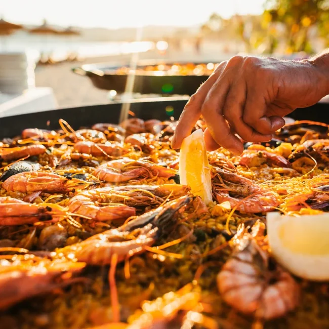 Eine Pfanne mit Paella aus Spanien, zubereitet mit Reis und verschiedenen Zutaten wie Meeresfrüchten.
