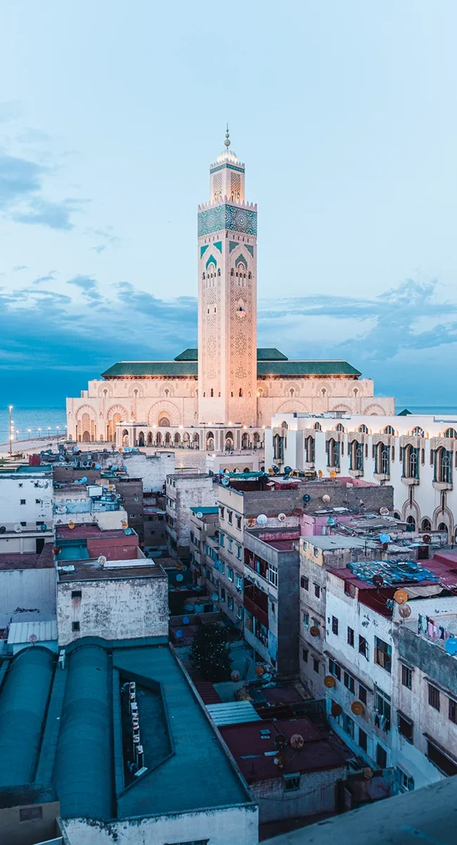 Die Hassan-II.-Moschee in Casablanca steht direkt an der Atlantikküste Marokkos. Das große Minarett und die weitläufige Moschee ragen über das Meer und die Stadt hinaus.