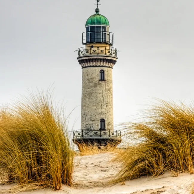 Leuchtturm in Warnemünde hinter Sanddünen an der Ostseeküste