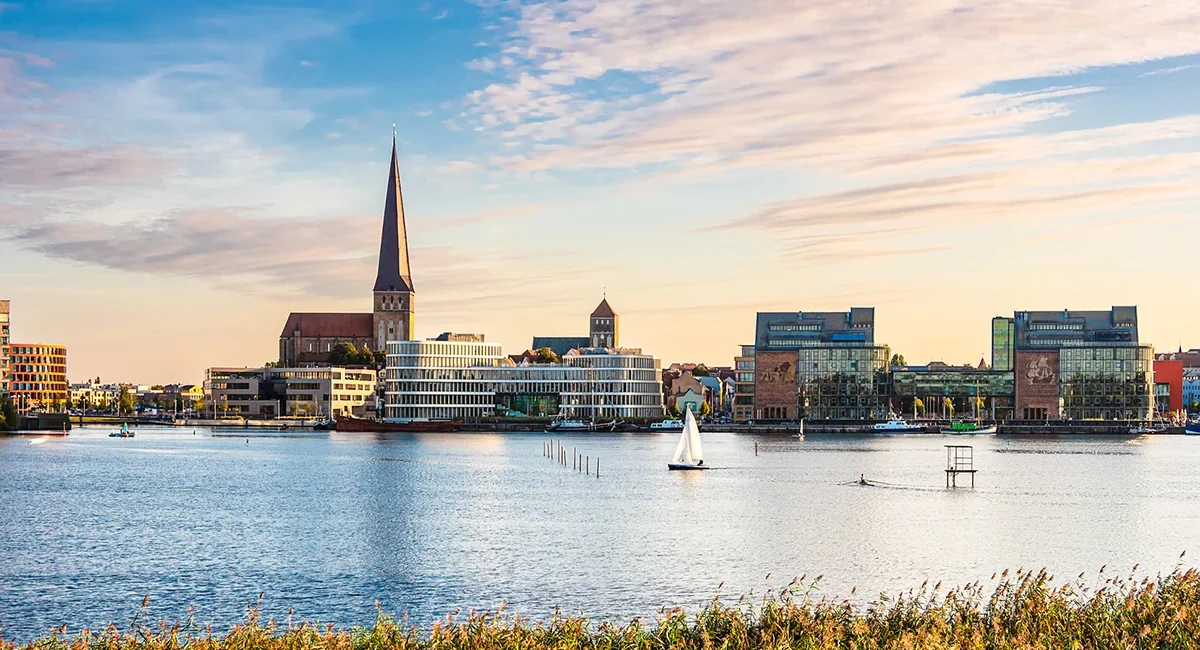 Blick auf Rostock mit Kirche, Wasser und der AIDA-Zentrale im Stadtbild