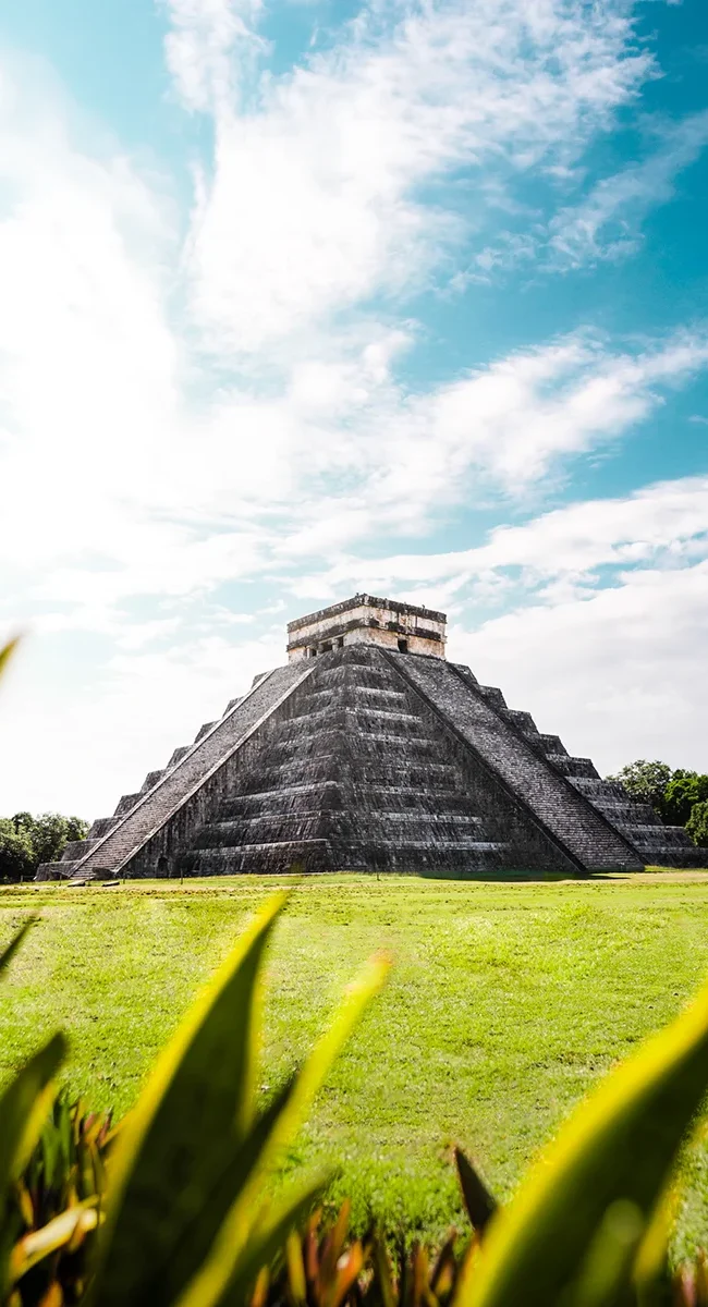 Die Maya-Pyramide El Castillo in Chichén Itzá in Mexiko erhebt sich über der archäologischen Stätte. Die steinernen Stufen der Pyramide führen zur Spitze des Tempels.