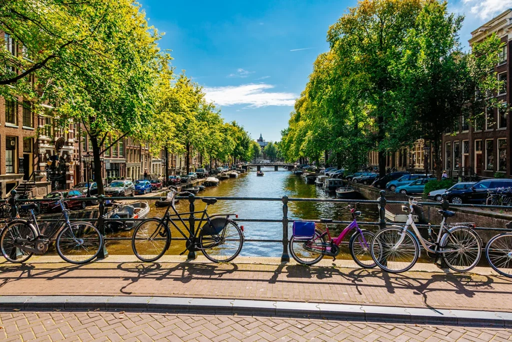 Fahrräder lehnen an einem Brückengeländer an einem Kanal in Amsterdam in den Niederlanden