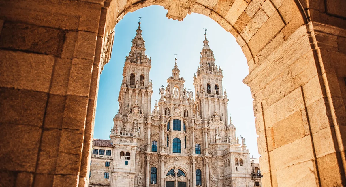 Die Kathedrale von Santiago de Compostela in Spanien mit ihrer großen historischen Fassade am Platz vor der Kirche.