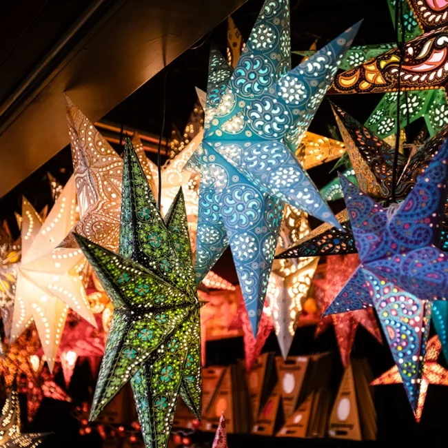 Leuchtende Papiersterne auf einem Weihnachtsmarkt als festliche Dekoration