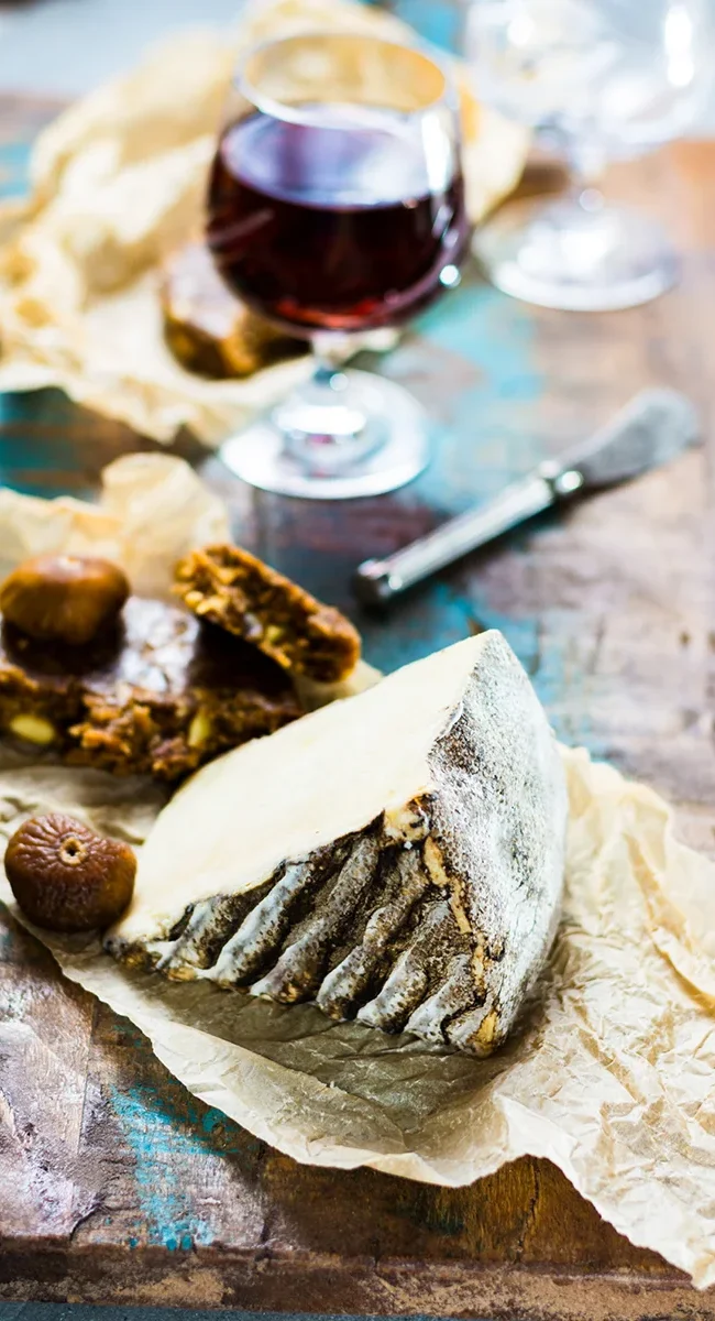 Ein Tisch mit Käse und einem Glas Wein in Portugal.