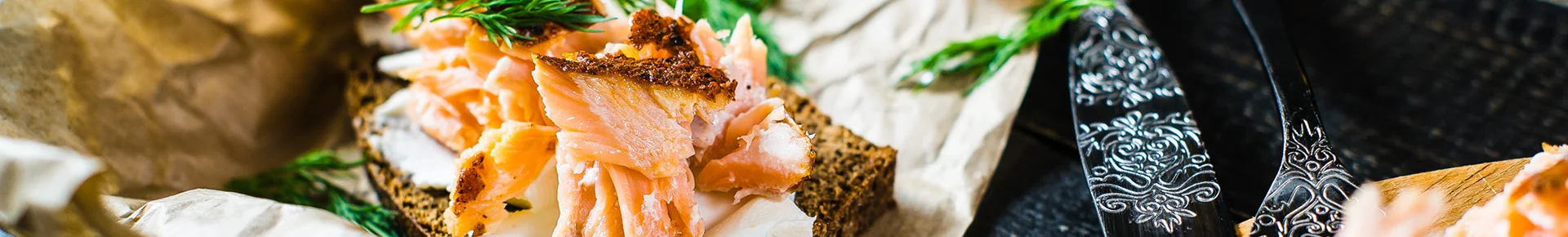 Ein Fischbrot aus Schweden mit Fisch auf einer Scheibe Brot. Das belegte Brot ist mit weiteren Zutaten dekoriert.