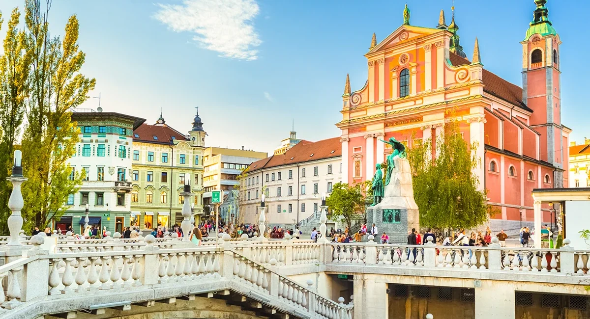 Die Franziskanerkirche am Prešerenplatz in Ljubljana ist von der anderen Seite der Brücke über die Ljubljanica zu sehen.