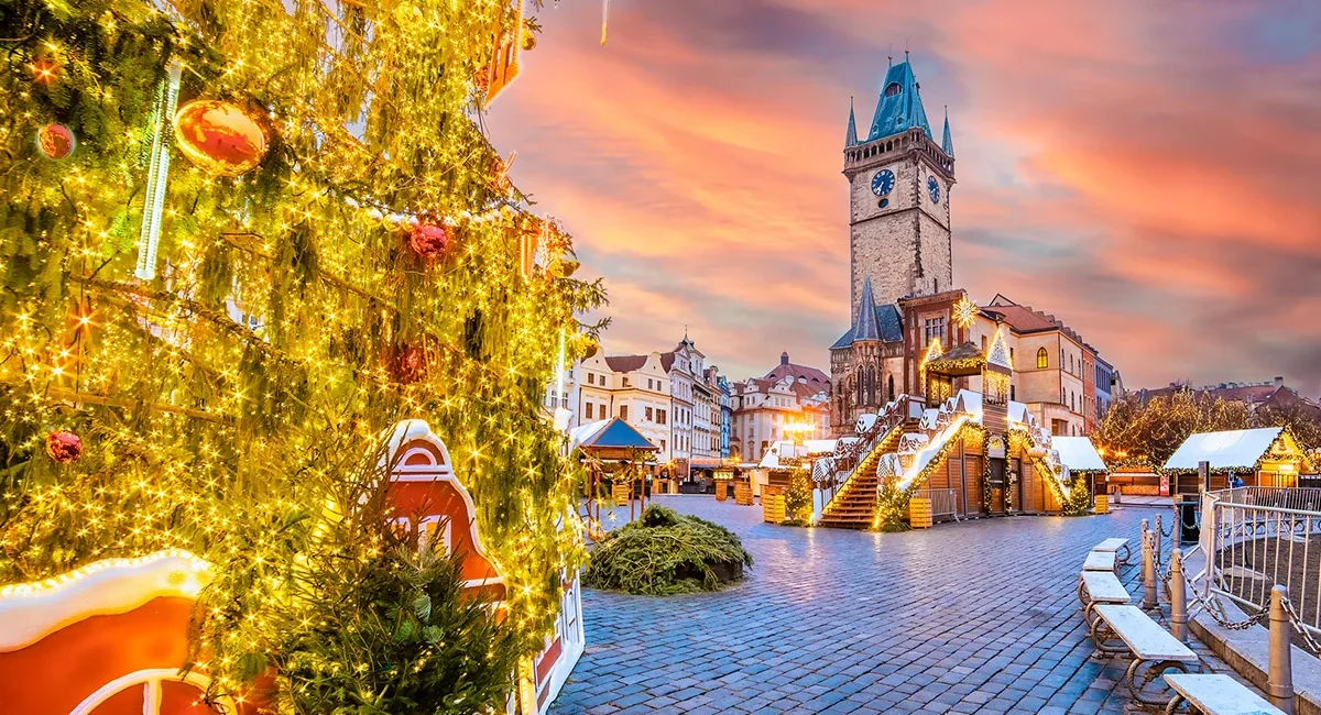 Ein Weihnachtsmarkt in Prag mit vielen festlich geschmückten Marktständen und Lichtern.