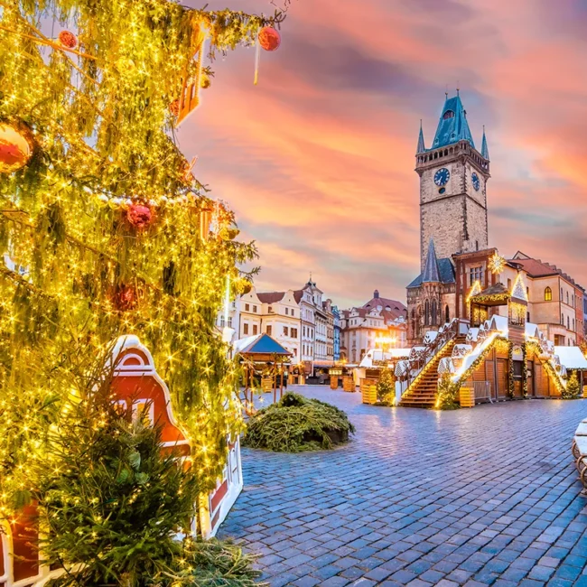 Ein Weihnachtsmarkt in Prag mit vielen festlich geschmückten Marktständen und Lichtern.