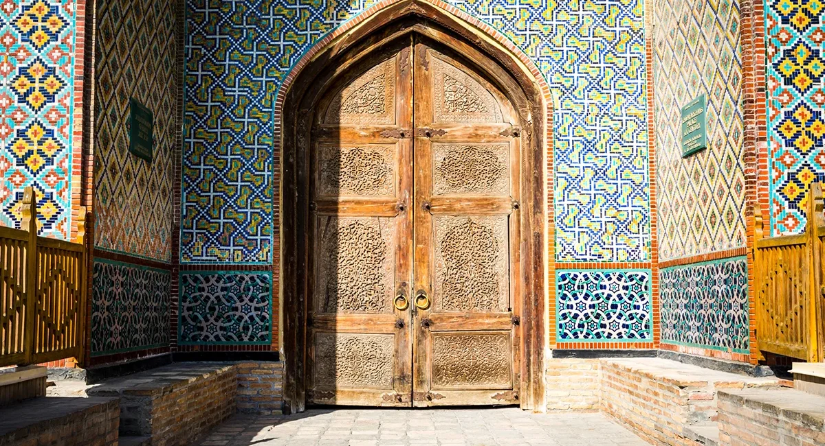 Verzierte Palasttür mit bunten Mosaiken an einem historischen Gebäude in Usbekistan