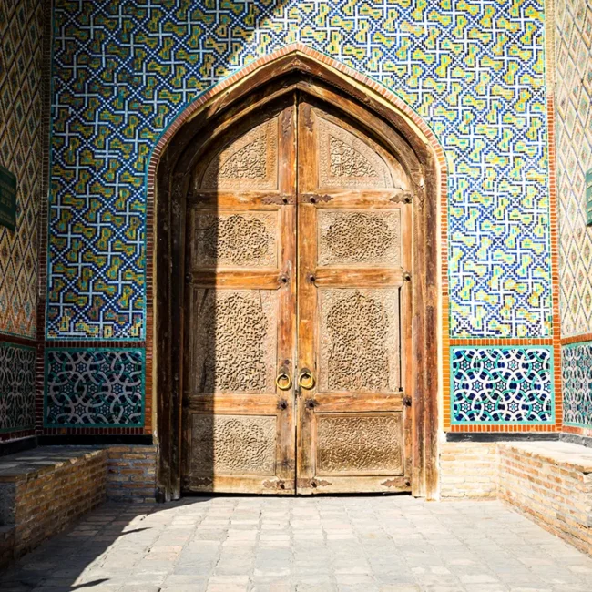 Verzierte Palasttür mit bunten Mosaiken an einem historischen Gebäude in Usbekistan