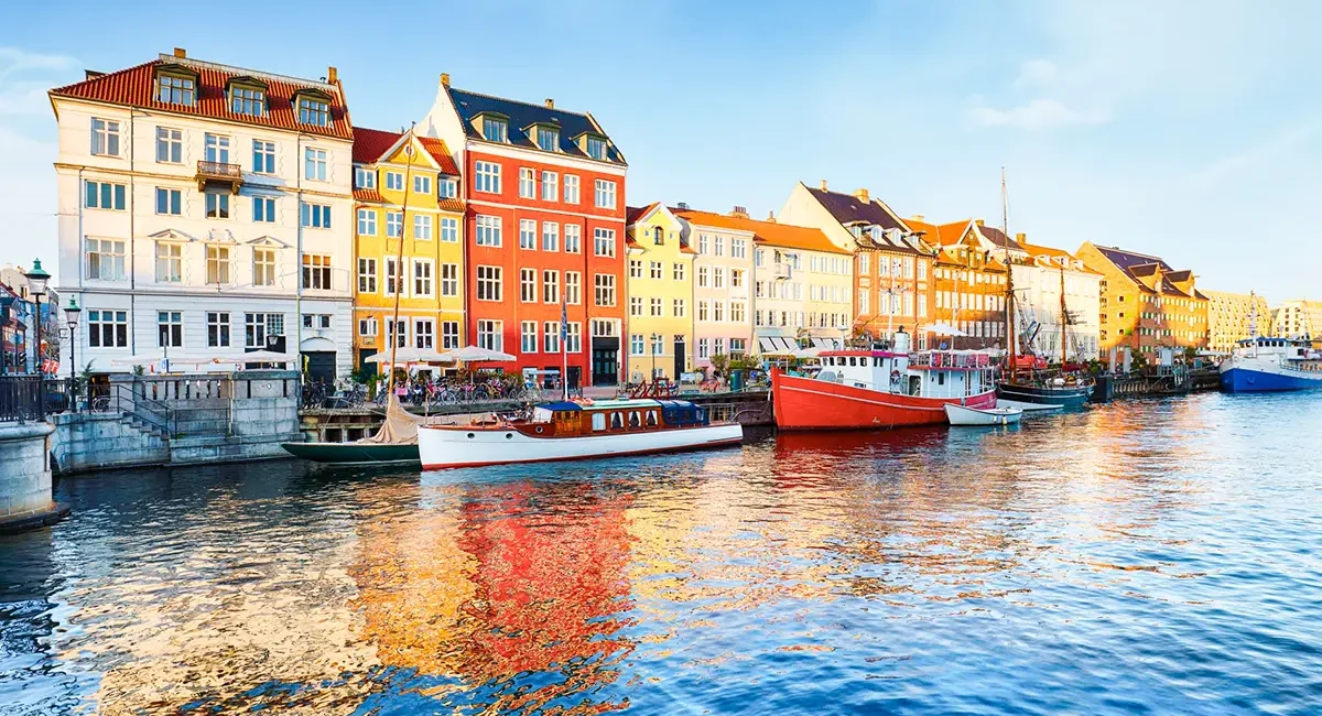 Nyhavn in Kopenhagen mit bunten Häusern entlang des Kanals und Booten am Ufer.