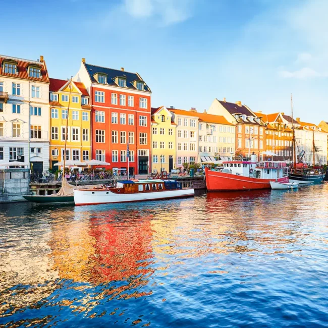 Nyhavn in Kopenhagen mit bunten Häusern entlang des Kanals und Booten am Ufer.