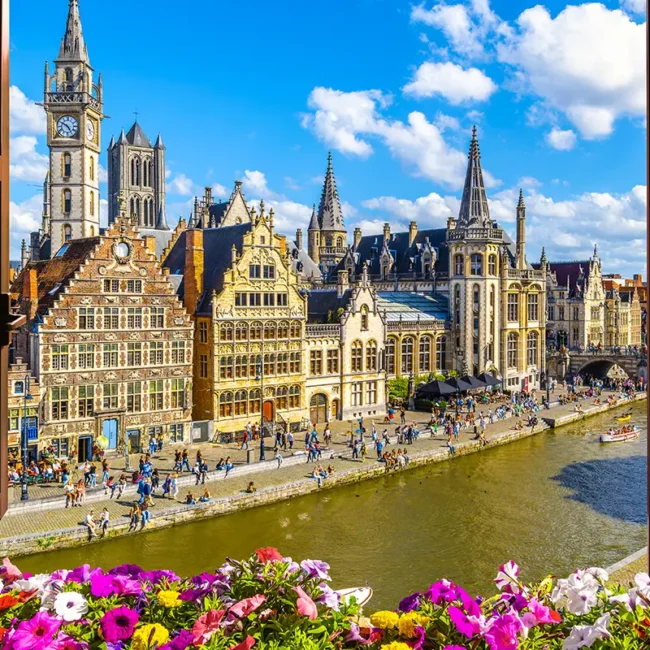 Blick aus einem Fenster in Gent auf einen Kanal und hübsche historische Gebäude.