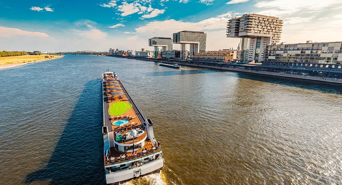 Vogelperspektive auf den Rhein in Köln mit einem Flusskreuzfahrtschiff und dem Medienhafen.