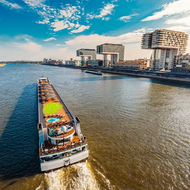 Vogelperspektive auf den Rhein in Köln mit einem Flusskreuzfahrtschiff und dem Medienhafen.