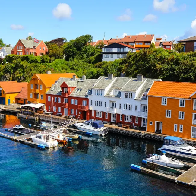 Der Hafen von Haugesund in Norwegen mit Booten am Wasser und Blick auf die Uferpromenade.